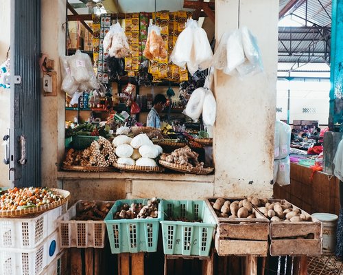 A busy traditional market in Indonesia displaying fresh vegetables and fruits