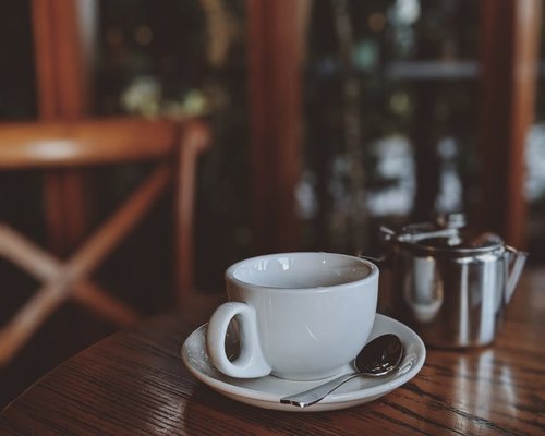 A warm cup of morning tea placed on a wooden table outdoors